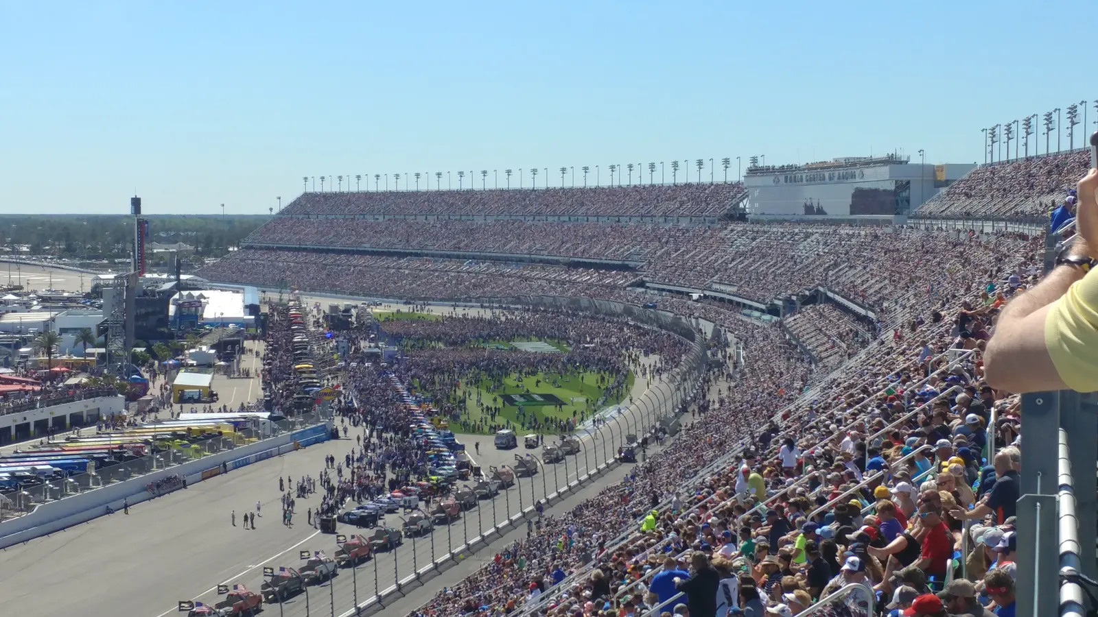 Fans fill the grandstands at Daytona International Speedway before the Daytona 500, seen from the upper level.